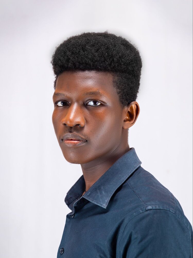 Portrait of a young man with short natural hair in a dark denim shirt