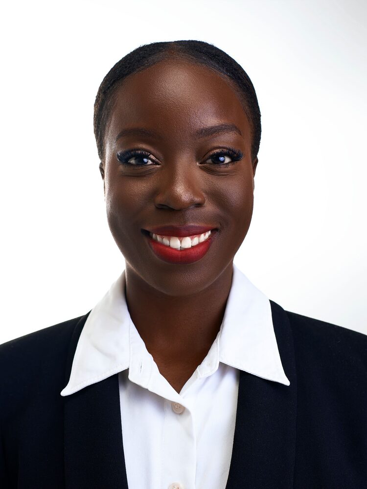 Portrait of a smiling woman in a black suit jacket and white blouse