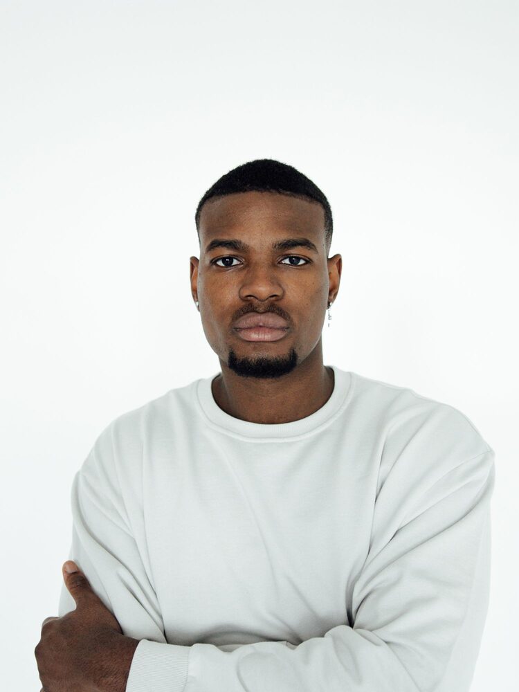 Portrait of a man in a white sweater with arms folded