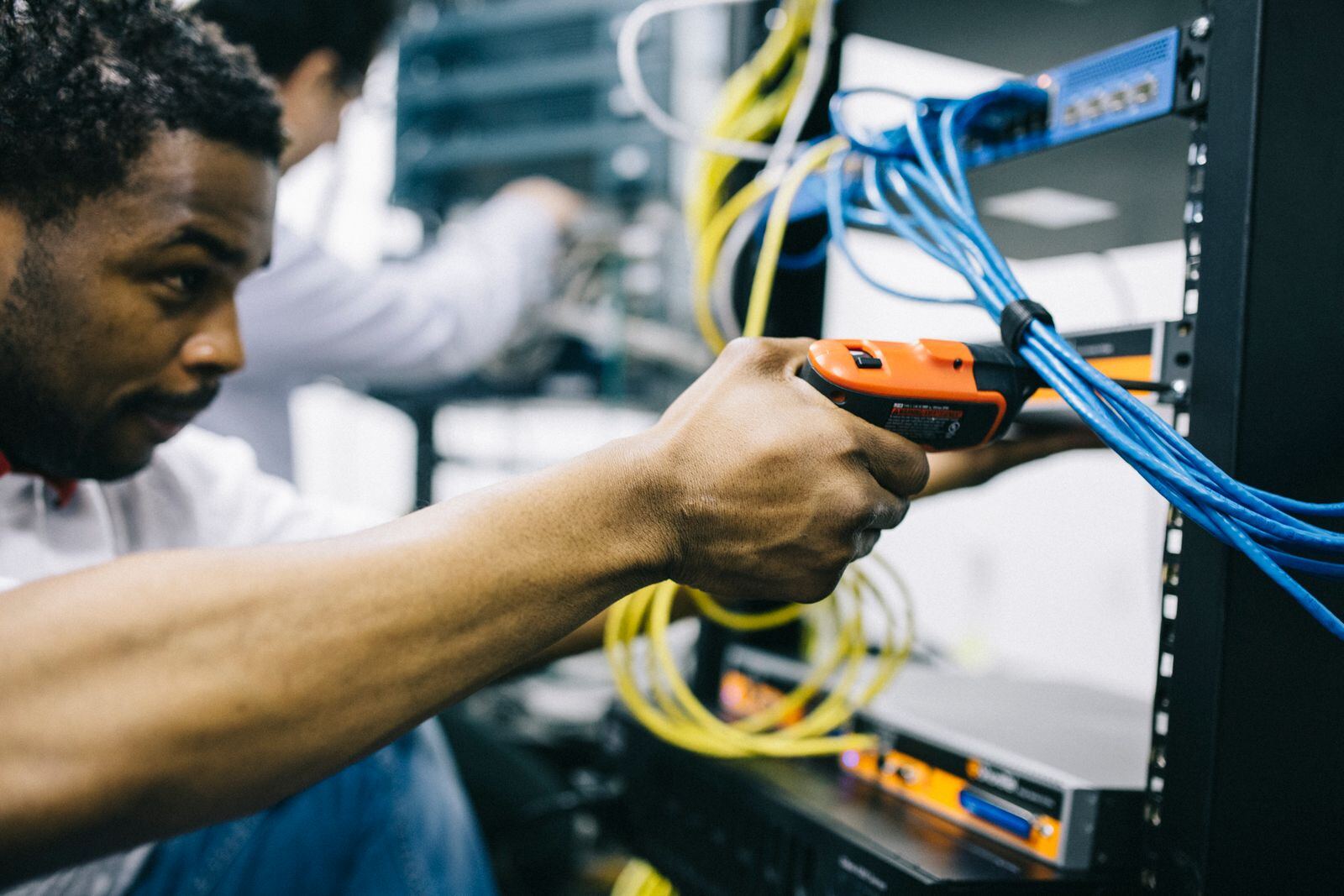 Engineer connecting network cables in a server rack
