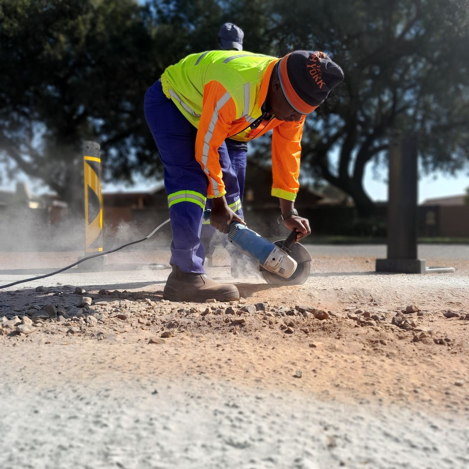 Worker cutting a road surface with a power tool