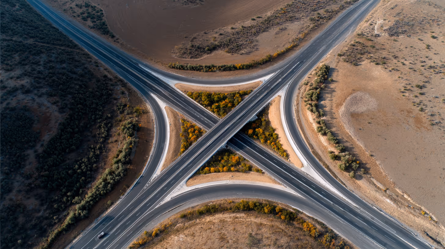 Aerial view of a highway overpass forming an X-shape over dry land.